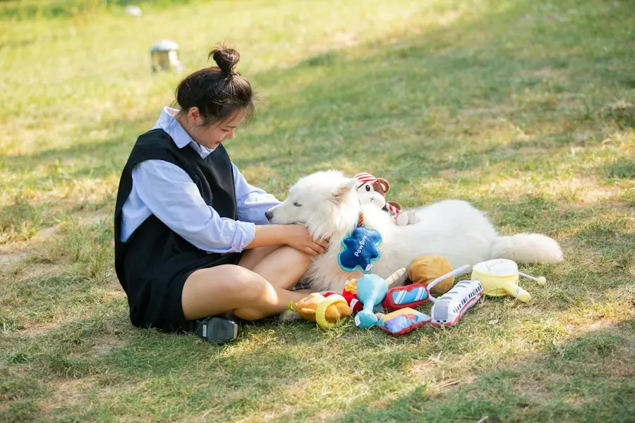 芝生でおもちゃに囲まれた白い犬とシッター